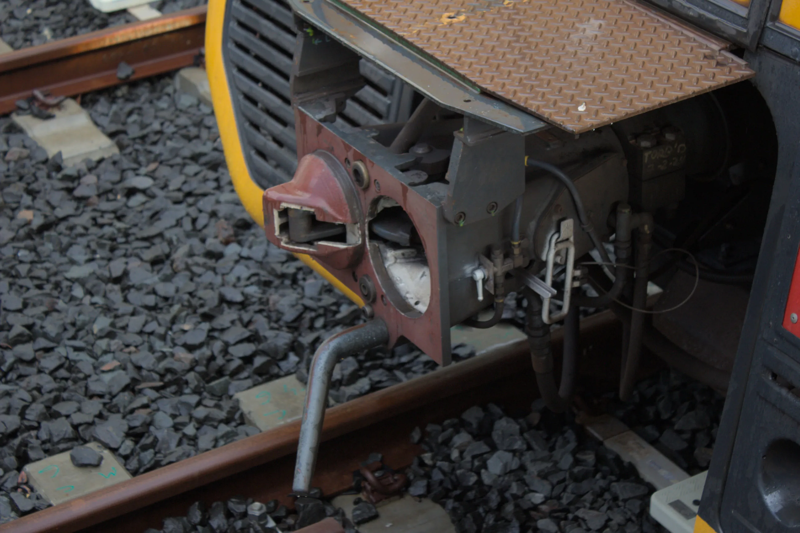 Close up shot of the Scharfenberg coupler on an unknown T set not attached to anything. The coupler face has been painted a maroon colour