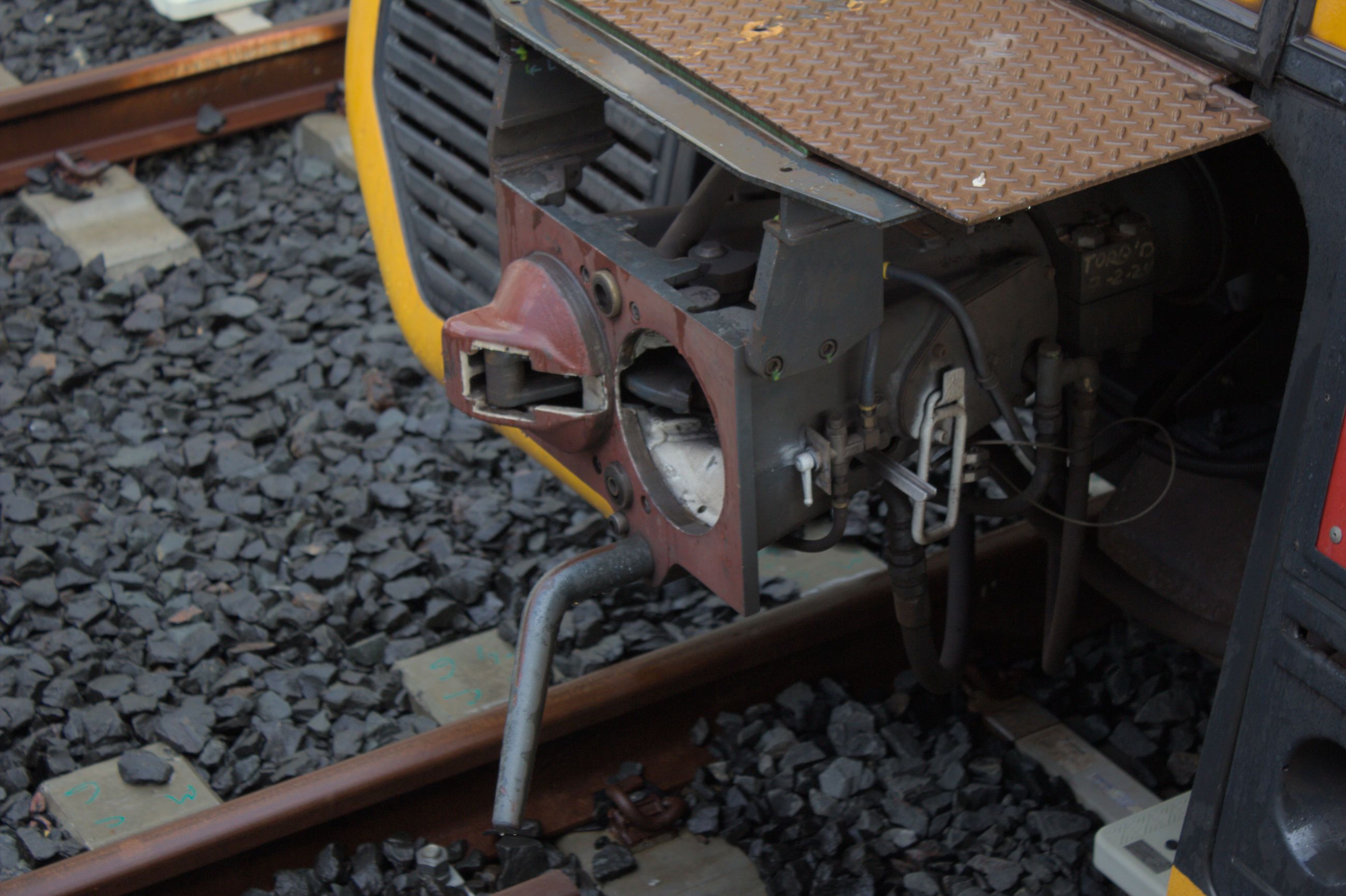 Close up shot of the Scharfenberg coupler on an unknown T set not attached to anything. The coupler face has been painted a maroon colour